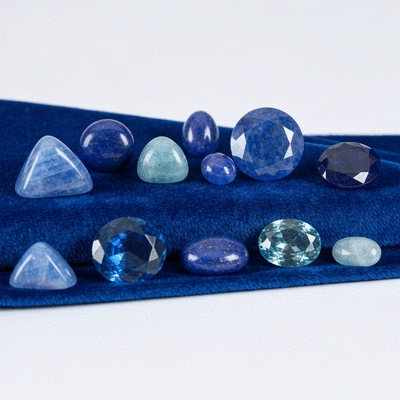 Assortment of blue gemstones for Leo birthstones on a velvet display