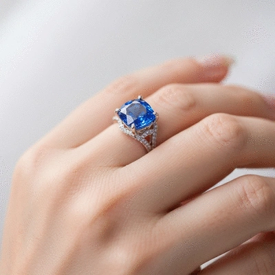 Close-up of a blue sapphire engagement ring on a hand