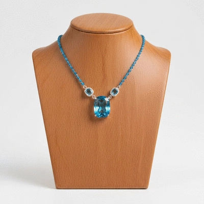 Blue topaz necklace on a jewelry display stand, clean background, no text, no words, no typography