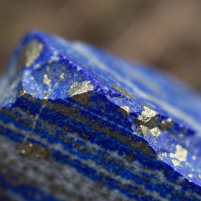 Close-up of a raw lapis lazuli stone with visible golden pyrite flecks, representing wisdom and spiritual insight